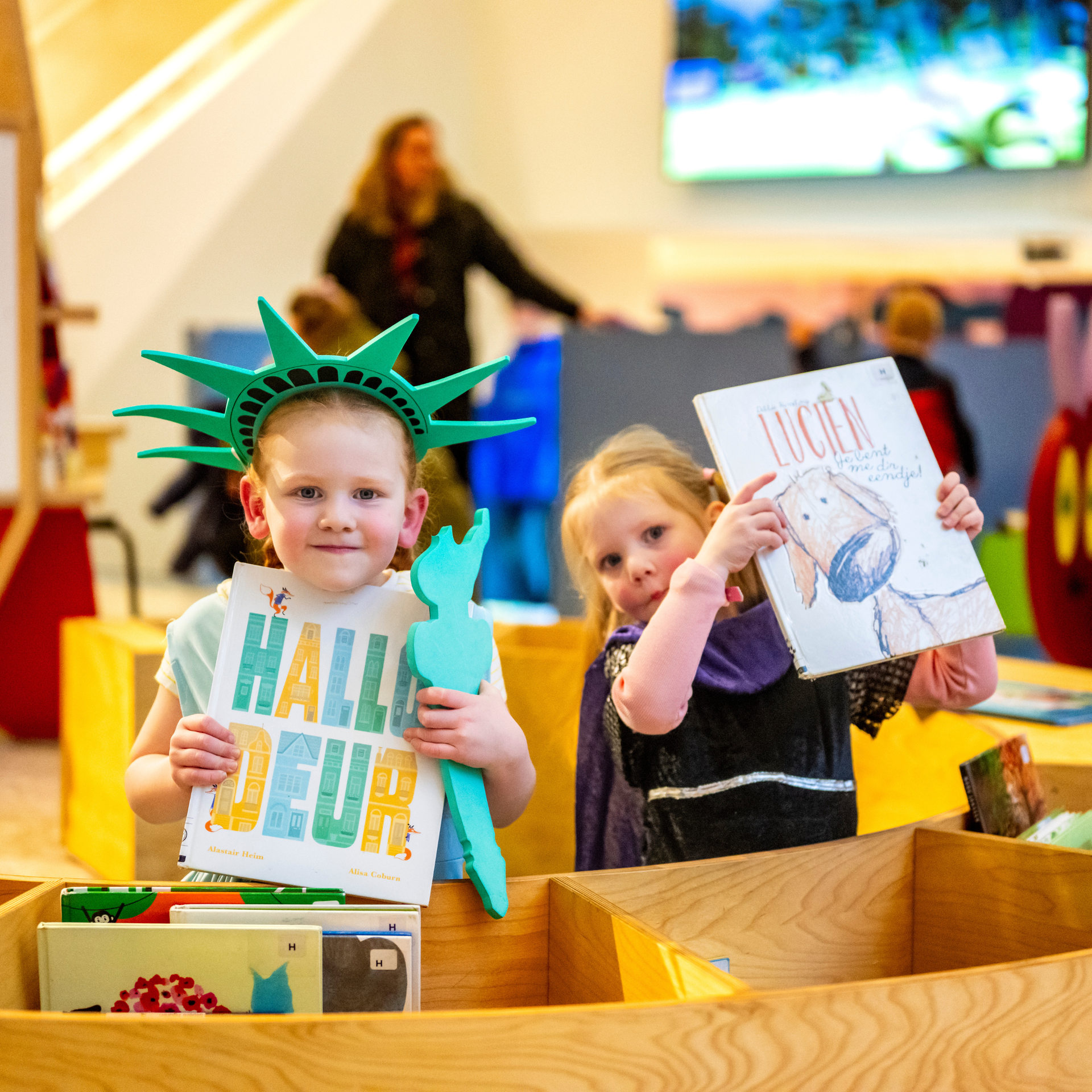 Meisjes houden prentenboeken omhoog. 