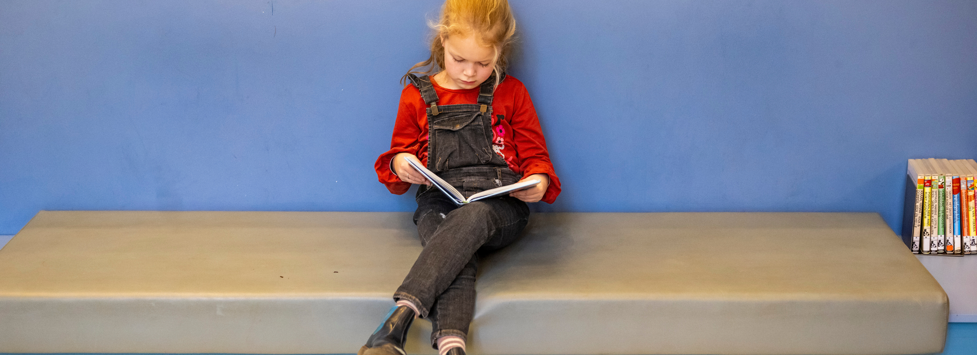 Meisje leest intensief haar boek.