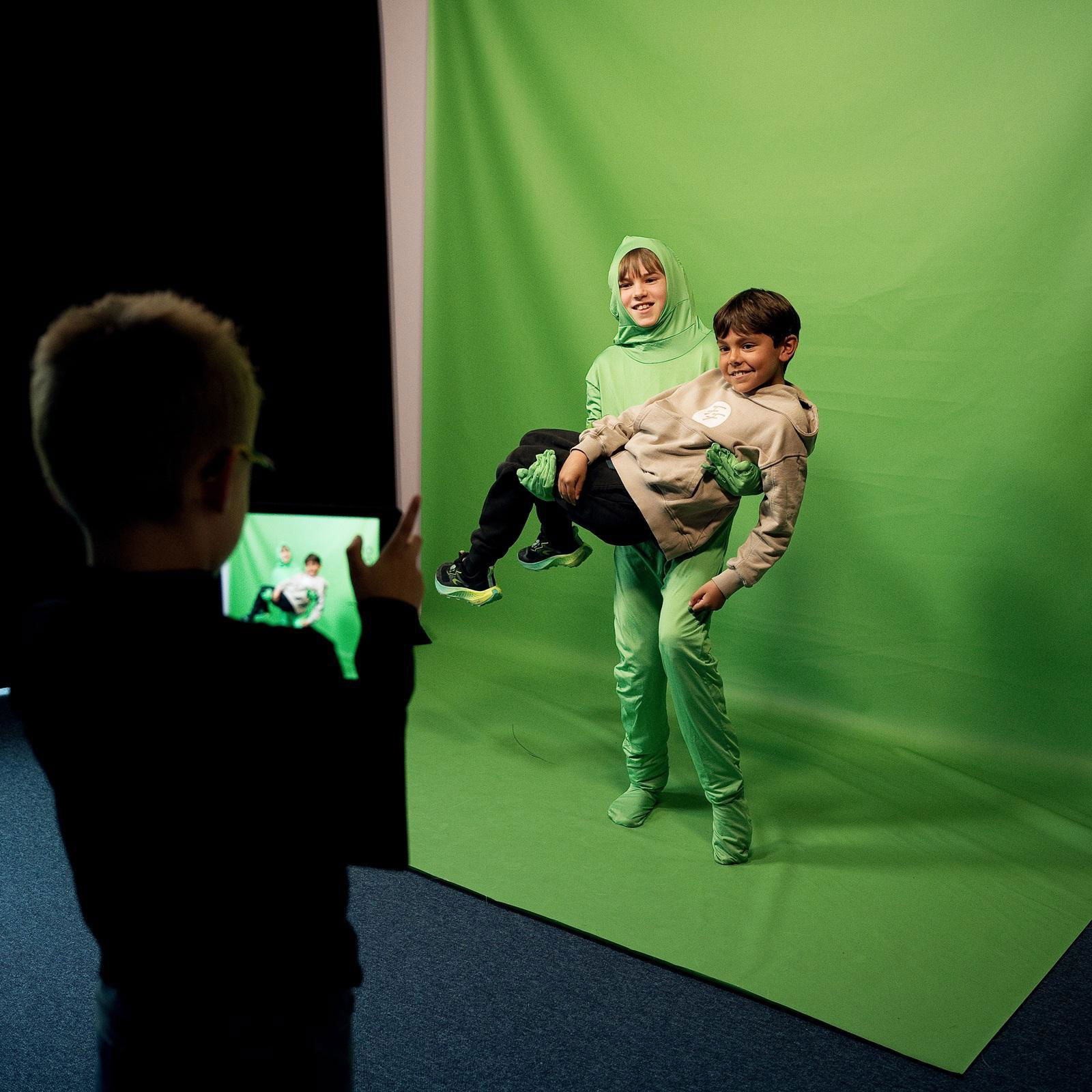 Drie jongens ontdekken de greenscreen.