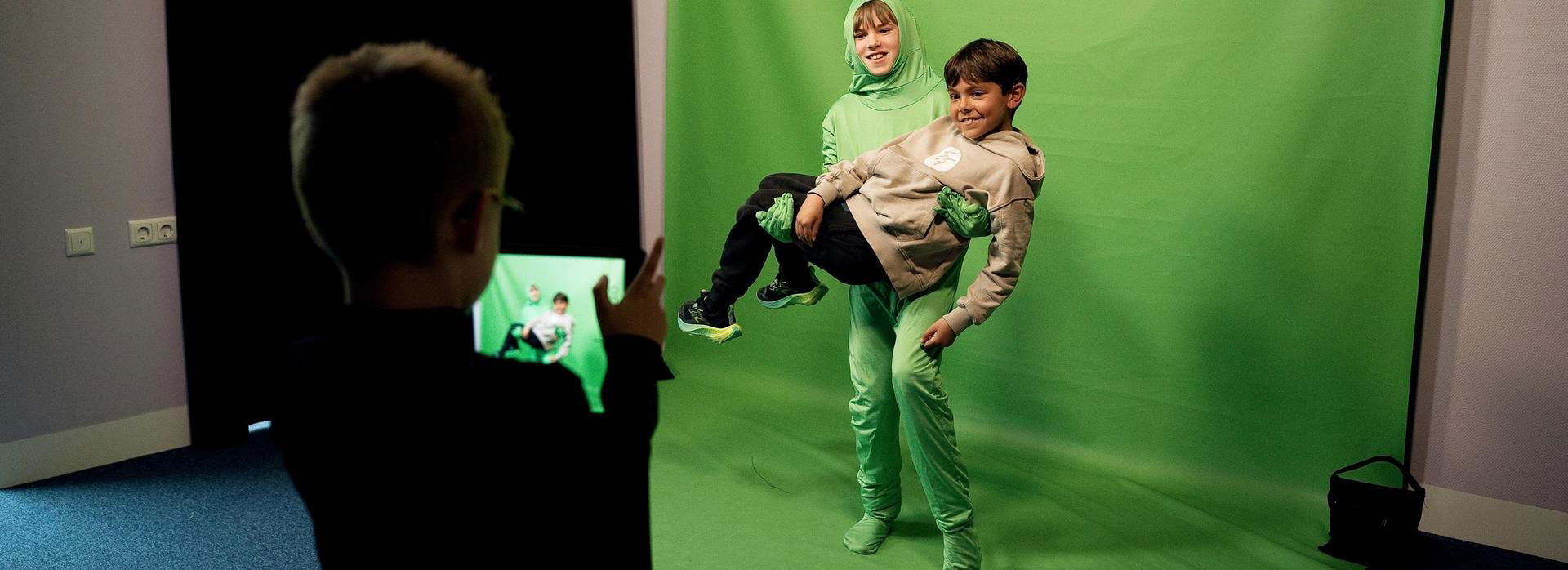 Drie jongens ontdekken de greenscreen.
