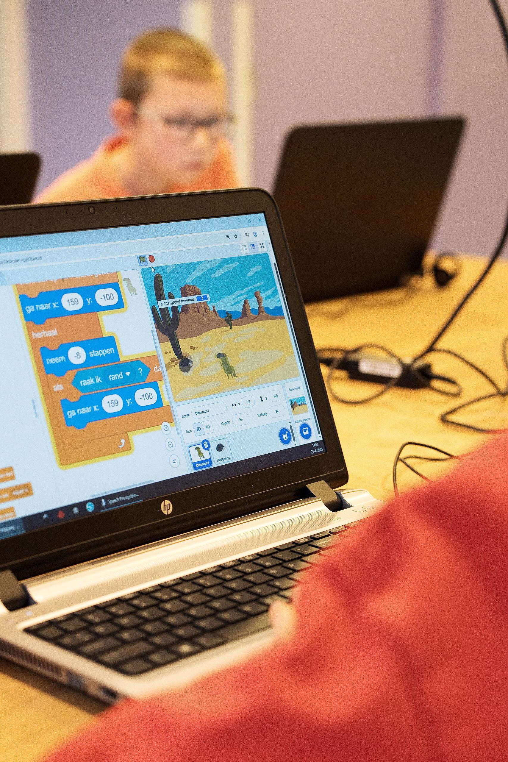 Jongen speelt Scratch op de laptop