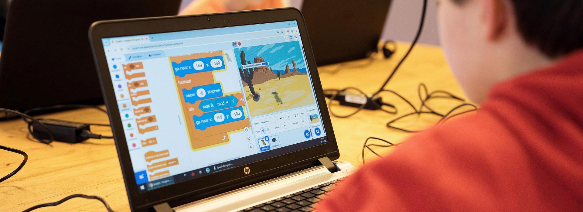 Jongen speelt Scratch op de laptop