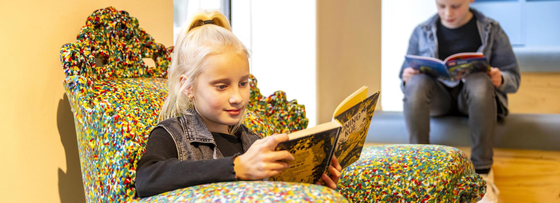 Twee kinderen lezen een boek.