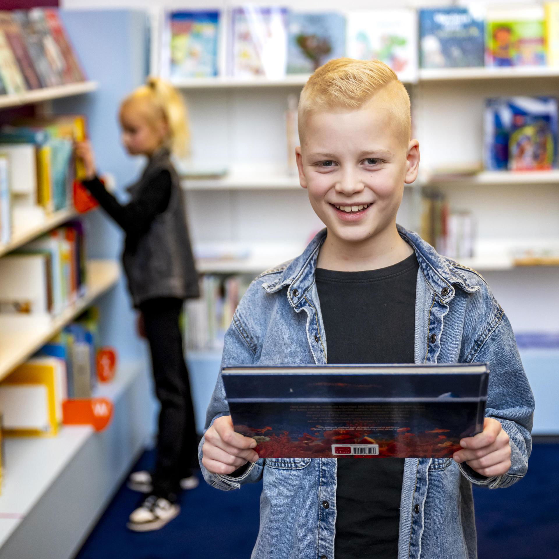 Jongen staat met een gekozen boek op de foto.