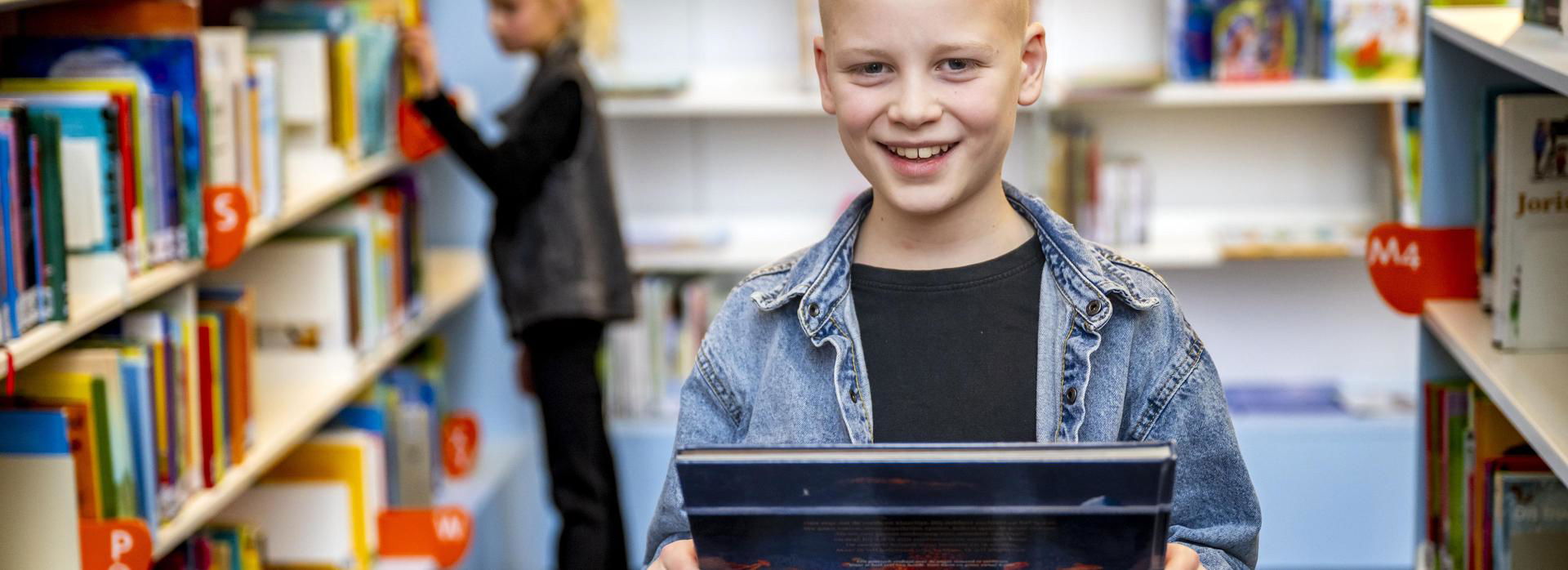 Jongen staat met een gekozen boek op de foto.