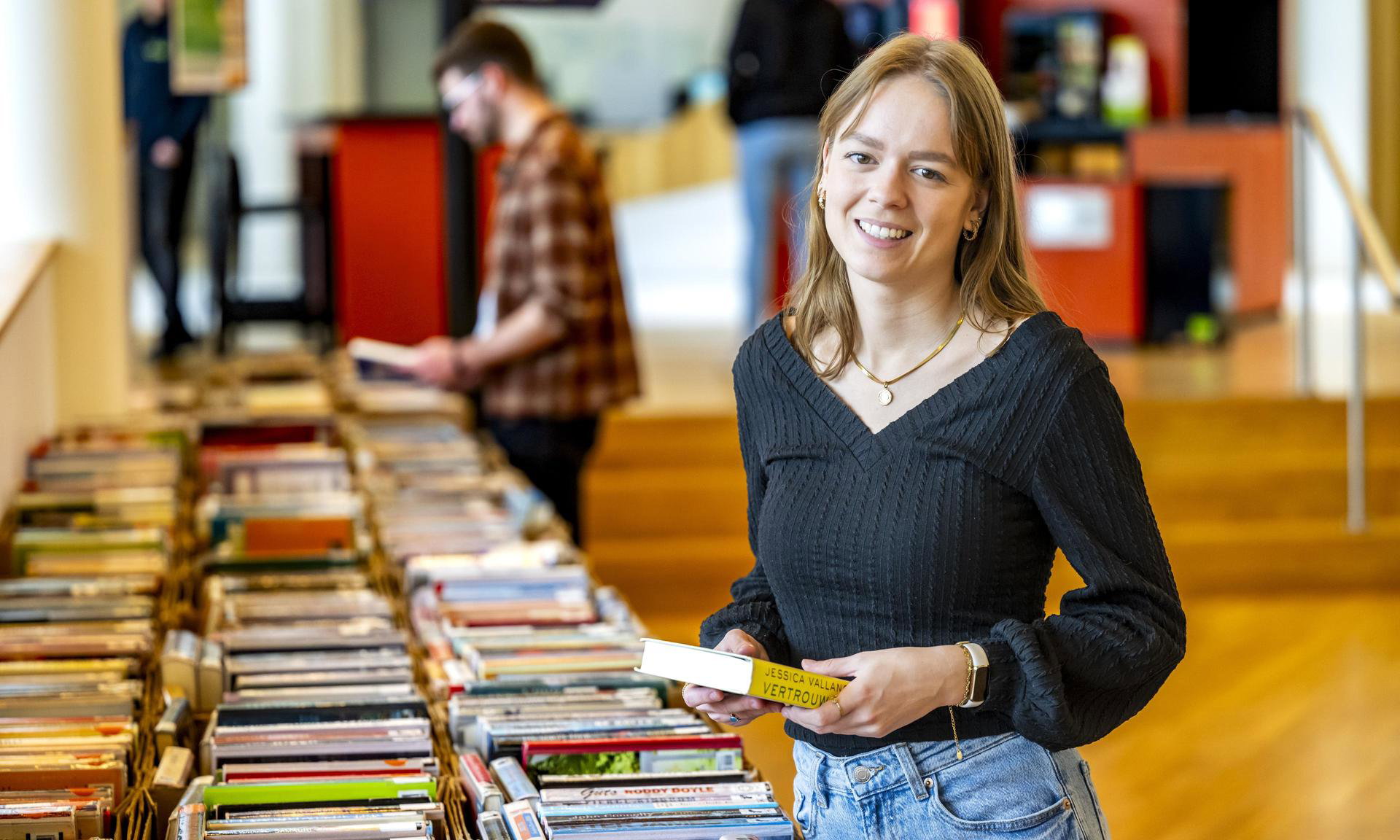 Meisje kiest een leesboek uit tijdens de boekverkoop in De Nieuwe Kolk.