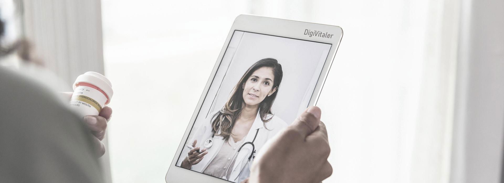 Persoon bekijkt op een tablet een video van een arts.