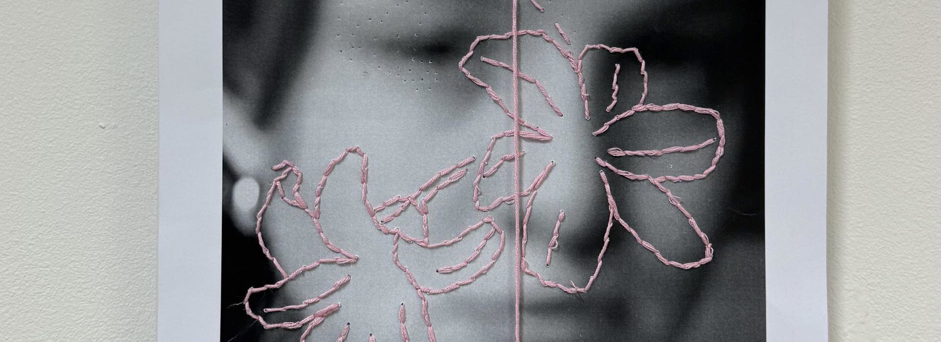 Kunstwerk over schisis: foto van kunstenaar met geborduurde bloemen erop