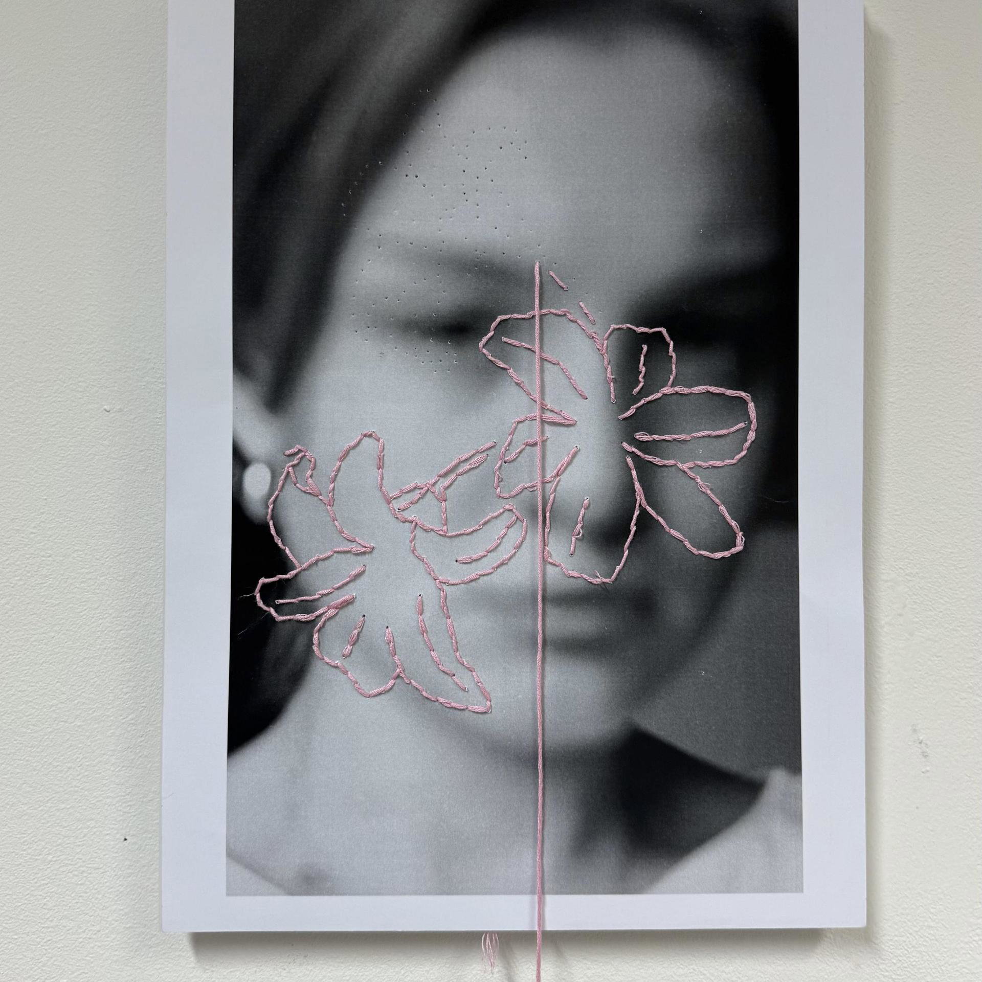 Artwork about schisis: photo of artist with embroidered flowers on it.